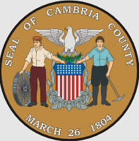 The seal of Cambria County features two figures holding a shield with stars and stripes, an eagle above, and the date March 26, 1804.